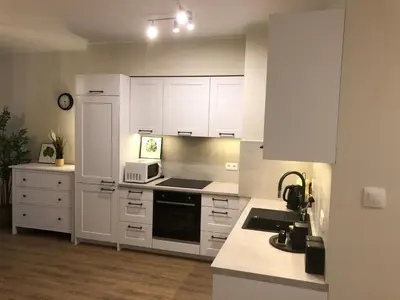 a kitchen with white cabinets and a stove top oven at Wislane Tarasy 2.0 by Atrium Apartments in Kraków