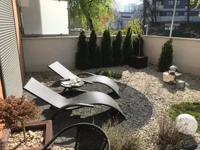 a garden with a table and a computer on it at Wislane Tarasy 2.0 by Atrium Apartments in Kraków