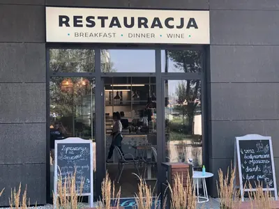 a restaurant with signs in the front of a building at Wislane Tarasy 2.0 by Atrium Apartments in Kraków
