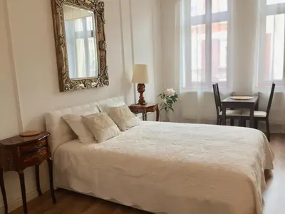 a bedroom with a white bed with a mirror on the wall at Studio Appartment in Old Town Krakow in Kraków