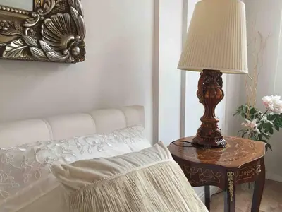 a lamp sitting on a table next to a bed at Studio Appartment in Old Town Krakow in Kraków