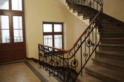 a staircase in a house with a wooden door and a stair railing at Studio Appartment in Old Town Krakow in Kraków