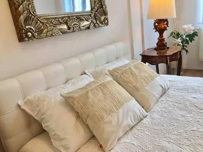 a white bed with two pillows and a mirror at Studio Appartment in Old Town Krakow in Kraków