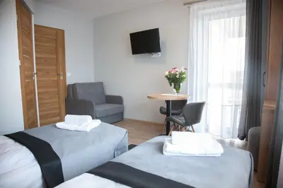 a hotel room with two beds and a chair at Willa-Wita in Kalwaria Zebrzydowska