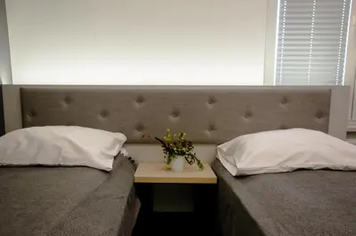 two beds with pillows and a table with flowers on it at ULMA studio in Wieliczka