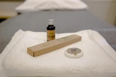 a bottle of oil sitting on a towel on a bed at ULMA studio in Wieliczka