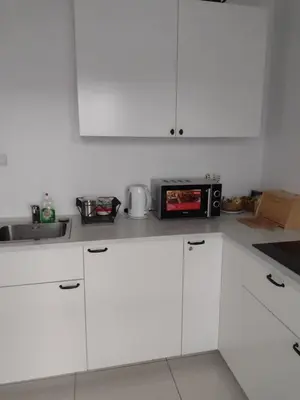 a kitchen with white cabinets and a microwave at Joanna in Kraków