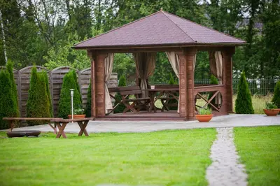 a wooden gazebo with a bench in a yard at Zielona willa in Rabka