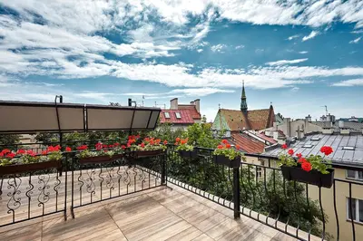 a balcony with flowers and a view of a city at Hotel Jan in Kraków