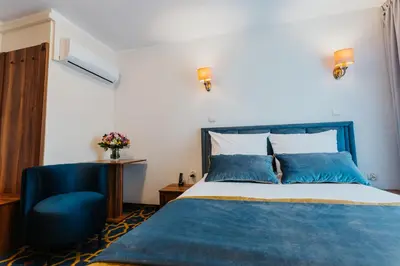 a bedroom with a blue bed and a blue chair at Hotel Jan in Kraków