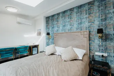 a bedroom with a bed and a blue tiled wall at Hotel Jan in Kraków