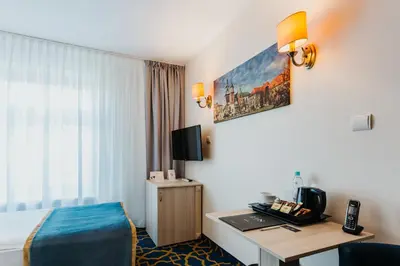 a hotel room with a bed and a desk at Hotel Jan in Kraków