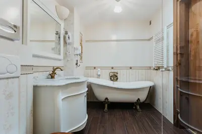 a white bathroom with a tub and a sink at Hotel Jan in Kraków