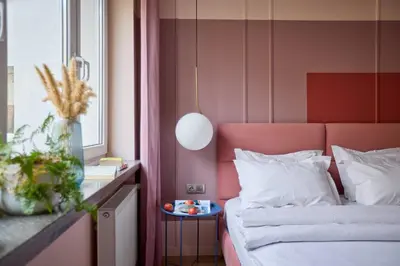 a bedroom with a bed with a pink head board at Polka Apartment 2-bed in Kraków