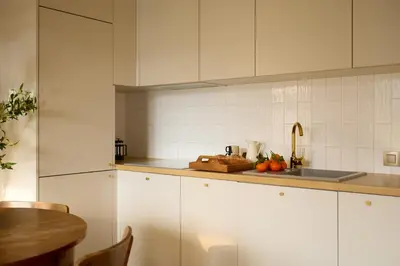 a kitchen with white cabinets and a sink at Polka Apartment 2-bed in Kraków