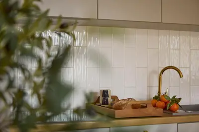 a kitchen counter with a sink with fruits and a faucet at Polka Apartment 2-bed in Kraków