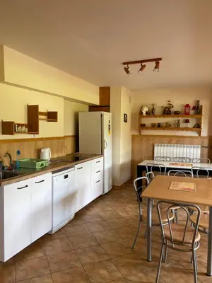a kitchen with white cabinets and a table at Willa Światowid in Rabka