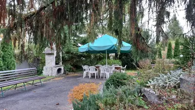 a table and chairs under an umbrella under a tree at Willa Światowid in Rabka