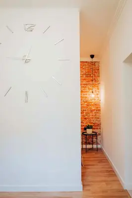 a hallway with a brick wall and a table at Cosy Apartment in Kraków