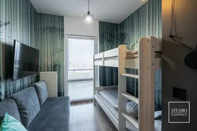 a bedroom with a bunk bed and a couch at Apartamenty Premium New in Wadowice