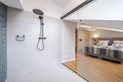 a bathroom with a shower and a bed in a room at Old Town Vistula Premium Apartments in Kraków