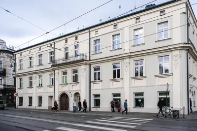 a large white building with people walking in front of it at Old Town Vistula Premium Apartments in Kraków