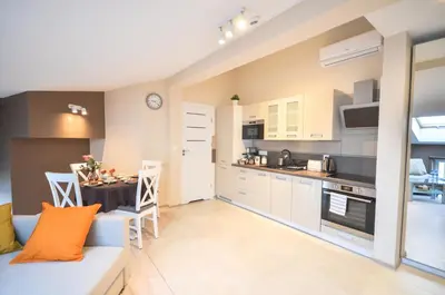a kitchen and living room with a couch and a table at Old Town Vistula Premium Apartments in Kraków