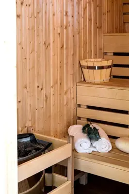 a sauna with wooden walls and two beds with towels at Old Town Vistula Premium Apartments in Kraków