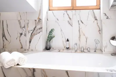 a bathroom with a bathtub with towels and a window at Old Town Vistula Premium Apartments in Kraków