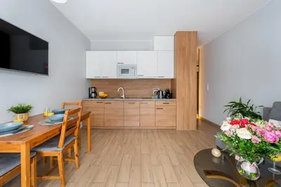 a kitchen and dining room with a table and a dining room gmaxwell gmaxwell at STEAM PARK Krakow Apartment in Kraków