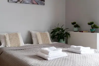 a white bed with two folded towels on it at STEAM PARK Krakow Apartment in Kraków