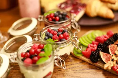 a table topped with jars of fruit and bread at Ventus Rosa Boutique Aparthotel in Kraków