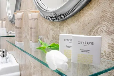 a glass shelf with some products on it in a bathroom at Ventus Rosa Boutique Aparthotel in Kraków