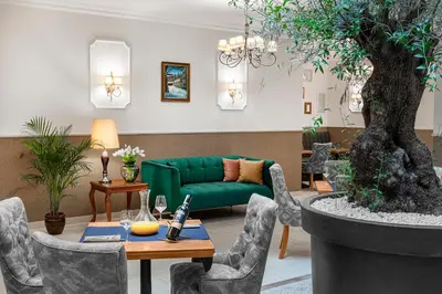 a living room with a green couch and a table at Ventus Rosa Boutique Aparthotel in Kraków