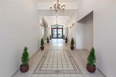 a hallway with potted plants and a chandelier at Ventus Rosa Boutique Aparthotel in Kraków