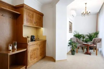 a kitchen with wooden cabinets and a dining room at Ventus Rosa Boutique Aparthotel in Kraków