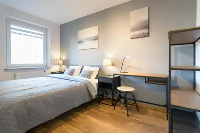 a bedroom with a bed and a desk at Wodna Street Big Family Apartment in Kraków