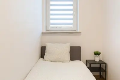 a bed in a bedroom with a window at Wodna Street Big Family Apartment in Kraków