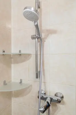 a shower with a shower head in a bathroom at Wodna Street Big Family Apartment in Kraków