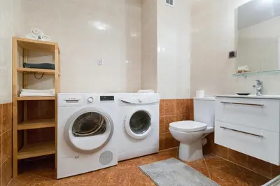 a bathroom with a washing machine and a toilet at Wodna Street Big Family Apartment in Kraków
