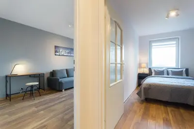 a bedroom with a bed and a couch and a window at Wodna Street Big Family Apartment in Kraków