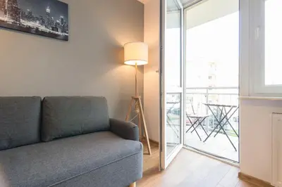a living room with a couch and a balcony at Wodna Street Big Family Apartment in Kraków