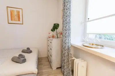 a white room with a bed and a window at Vintage Krasińskiego 7/4 Apartment in Kraków