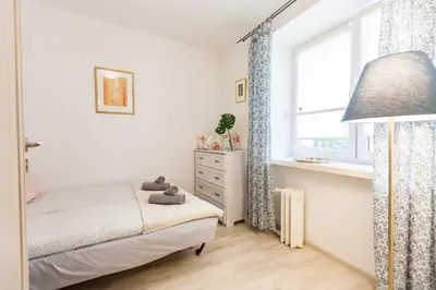 a small bedroom with a bed and a window at Vintage Krasińskiego 7/4 Apartment in Kraków