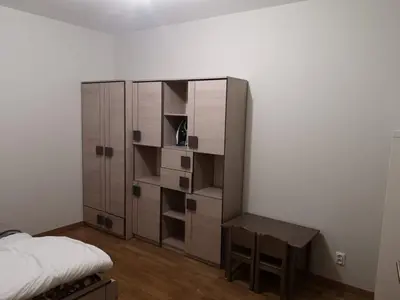 a bedroom with a bed and a desk and a cabinet at Appartement Nowa Huta in Kraków