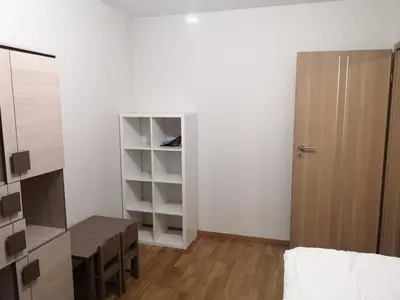 a bedroom with a bed and a desk and a closet at Appartement Nowa Huta in Kraków