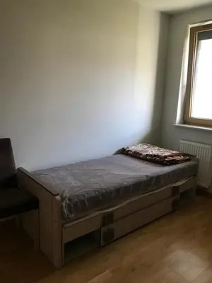 a bed in a room next to a window at Appartement Nowa Huta in Kraków