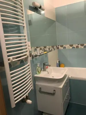 a bathroom with a sink and a mirror and a tub at Appartement Nowa Huta in Kraków