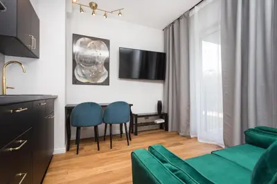 a living room with a couch and a table and chairs at City of the Kings - Nubium Apartment in Kraków