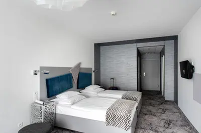 a bedroom with a bed with two towels on it at Hotel Lenart in Wieliczka